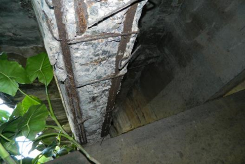Exposed and rusty
reinforcement on beams, some with broken strips